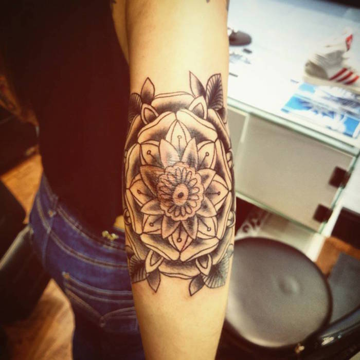 tatouage femme coude fleur lotus noir blanc
