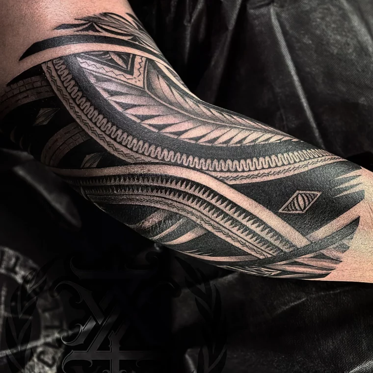 tatouage coude homme polynesien motifs tribaux details lignes noires