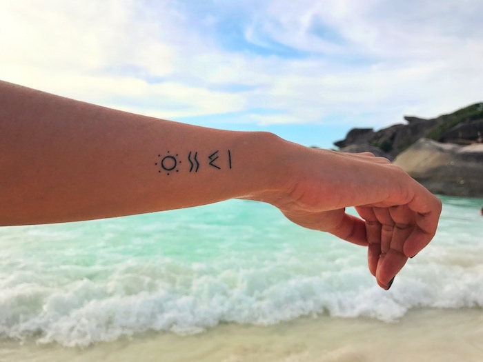 tatouage femme, océan turquoise et vagues, paysage mer et sable, dessin en encre symbolique