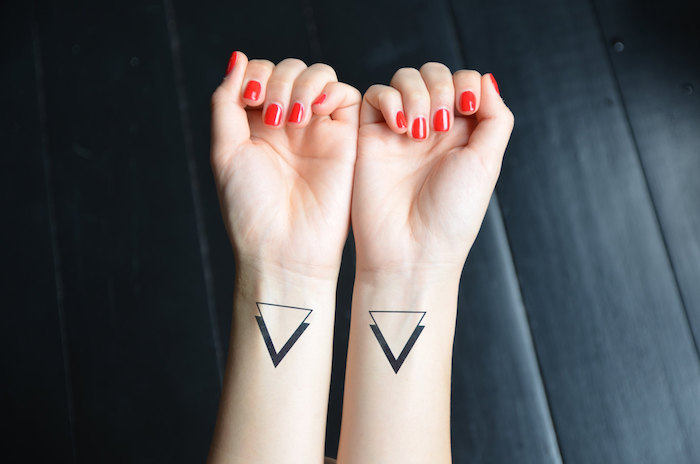 tatouage poignet femme, nail art rouge sur ongles courts, dessin en encre 3D avec triangles