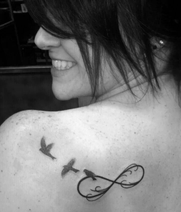 tatouage noeud de l'infini et oiseaux dans le dos