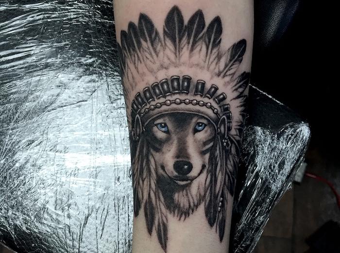 signification tatouage, dessin loup mignon aux yeux bleus avec couronne indienne, tatouage pour homme et femme