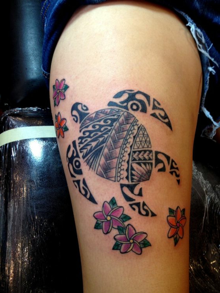 tatouage tortue maorie signification, tortue de mer noire flottant au sein de fleurs