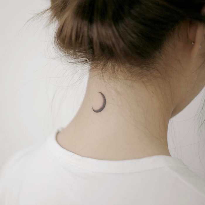 coiffure cheveux marron en chignon, piercing oreille pour femme, petit tatouage sur le cou design lune