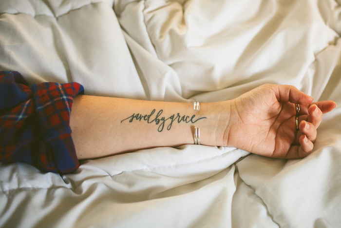 tatouage femme, dessin en encre sur le bras à design mots inspirants, bracelet métallique pour femme