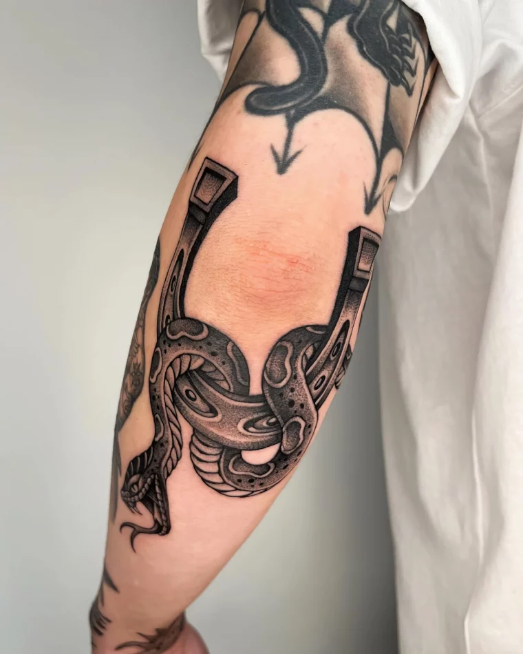 tatouage symbolique homme serpent fer de cheval peau detail