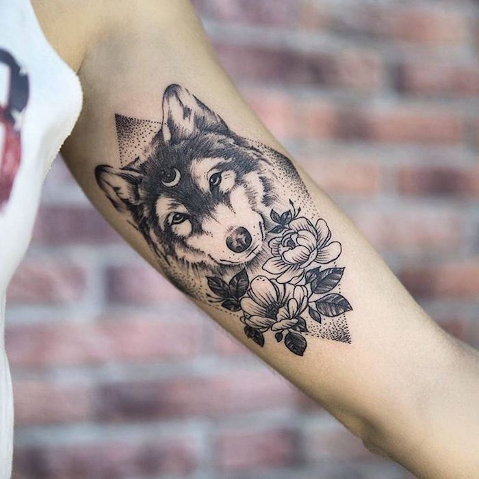 idée tatouage, modèle d'art corporel en encre avec tête de loup et fleurs sur le bras