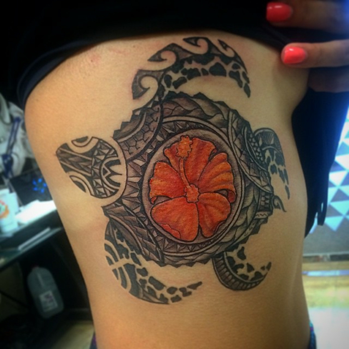 tatouage tortue sur les côtes avec hibiscus orange au centre de sa carapace