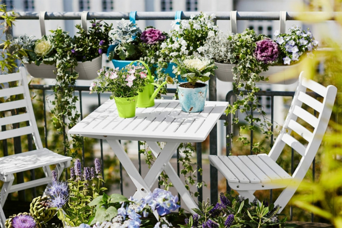 balcon, aménager sa terrasse, table et chaises blanches pliantes, deco de pots de fleurs avec des fleurs colorées