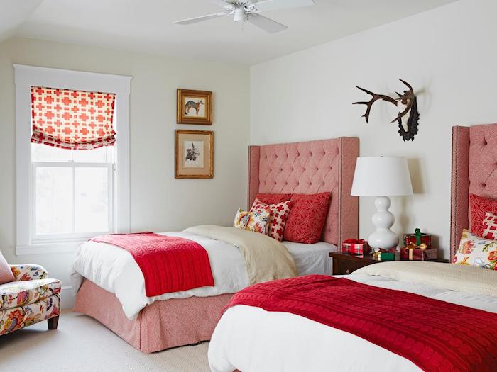 idée deco chambre à coucher avec des lits rose, tête de lit capitonnée, couvertures rouges, coussins colorés, fauteuil à motifs floraux, association de couleur