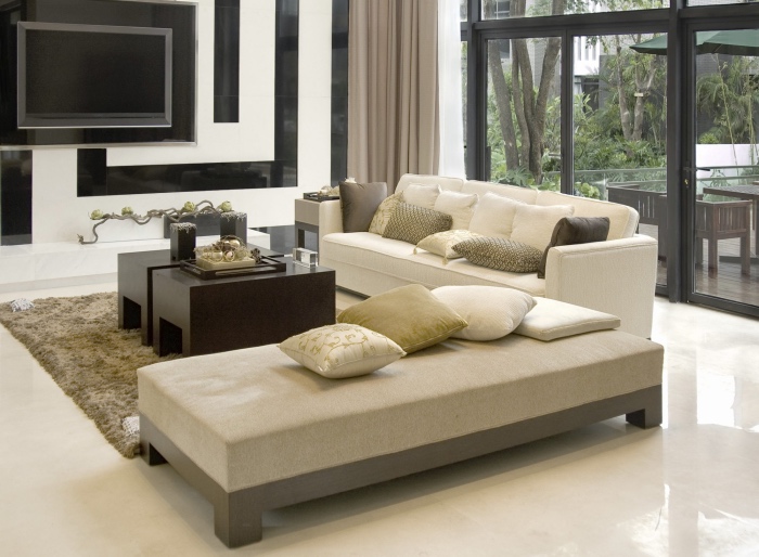 rideaux et chaise longue couleur lin, canapé et sol blanc cassé, table base en bois marron, mur d accent noir et blanc