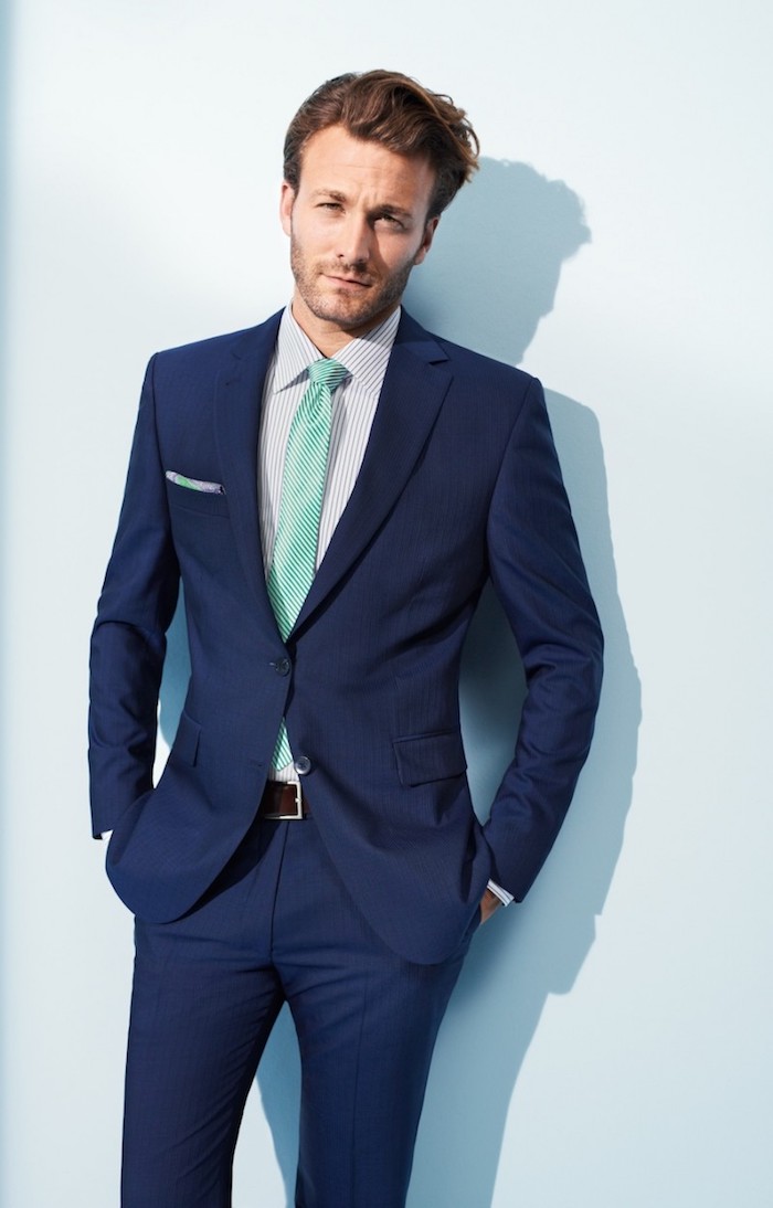 costume bleu marin, coupe de cheveux homme, ceinture marron et cravate verte
