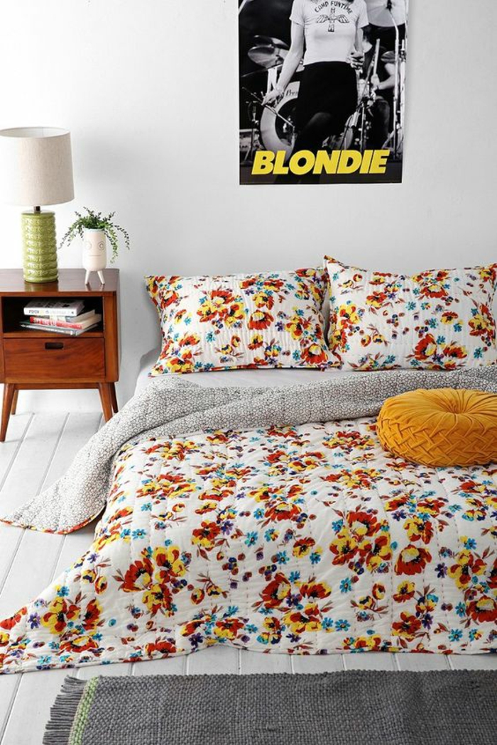 décoration chambre adulte avec lit tout en fleurs en orange et rouge et poster rock