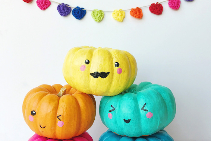 activite halloween, citrouilles repeintes de couleurs diverses, jaune, orange, bleu, avec des dessins de têtes amusantes