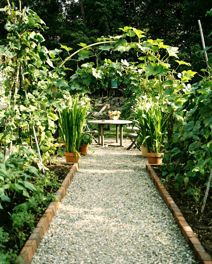 jardin mineral, sentier aux galets et cailloux blancs, bordure de jardin en briques, salon de jardin en bois vintage