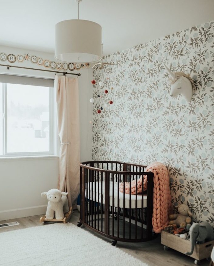 papier peint enfant, chambre bébé fille, lit bebe en bois marron à roulettes, tapis blanc, coffre bois à jouets, tapisserie, imprimé floral