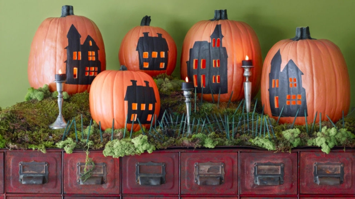 activité manuelle halloween avec des citrouilles et maisons silhouettes noires dessinées dessus et petit fenêtres ouvertures, lanterne halloween