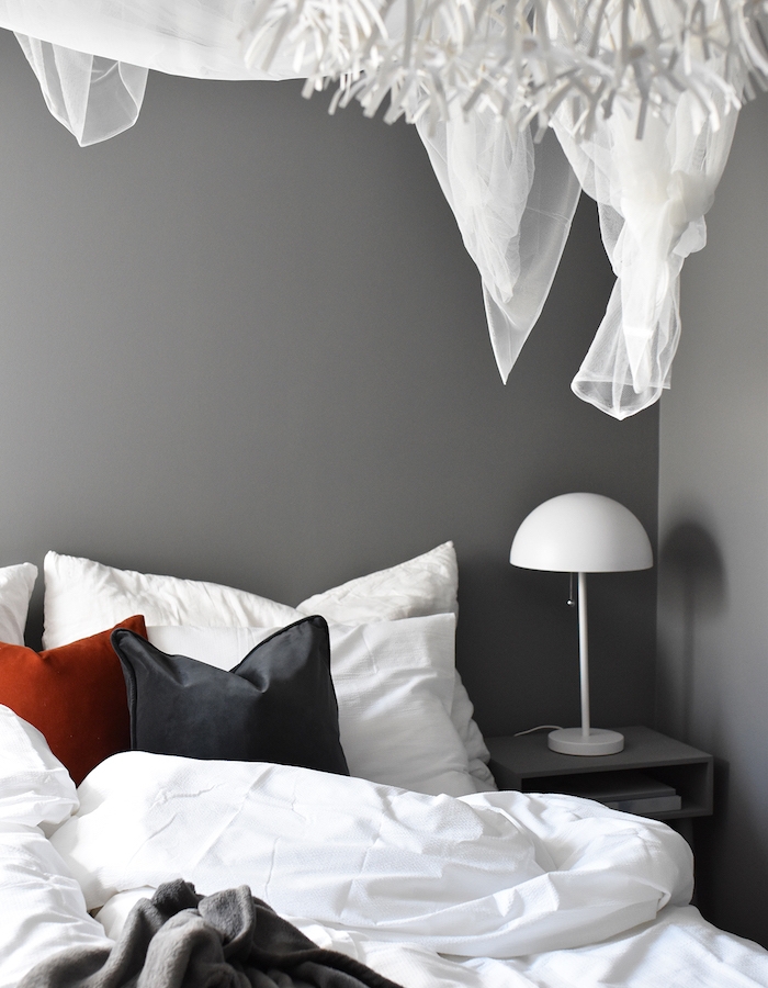 deco chambre parentale avec murs couleur grise et linge de lit gris, blanc et rouge, lampe de nuit design simple