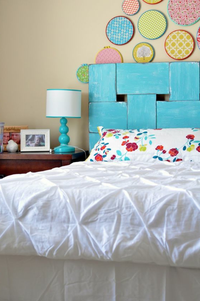 déco chambre adulte avec tete de lit en bleu azur et des panneau décoratifs en forme ronde avec des motifs et des couleurs différents 
