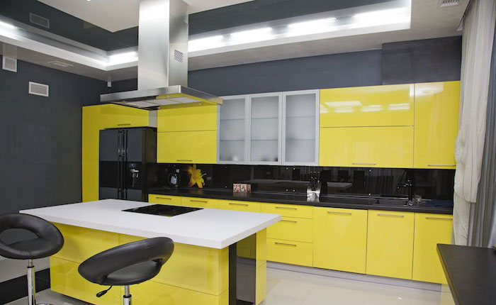 meuble bas cuisine, décoration de cuisine en noir et jaune, cuisine avec ilot centrale blanc et jaune avec tabourets de bar noirs