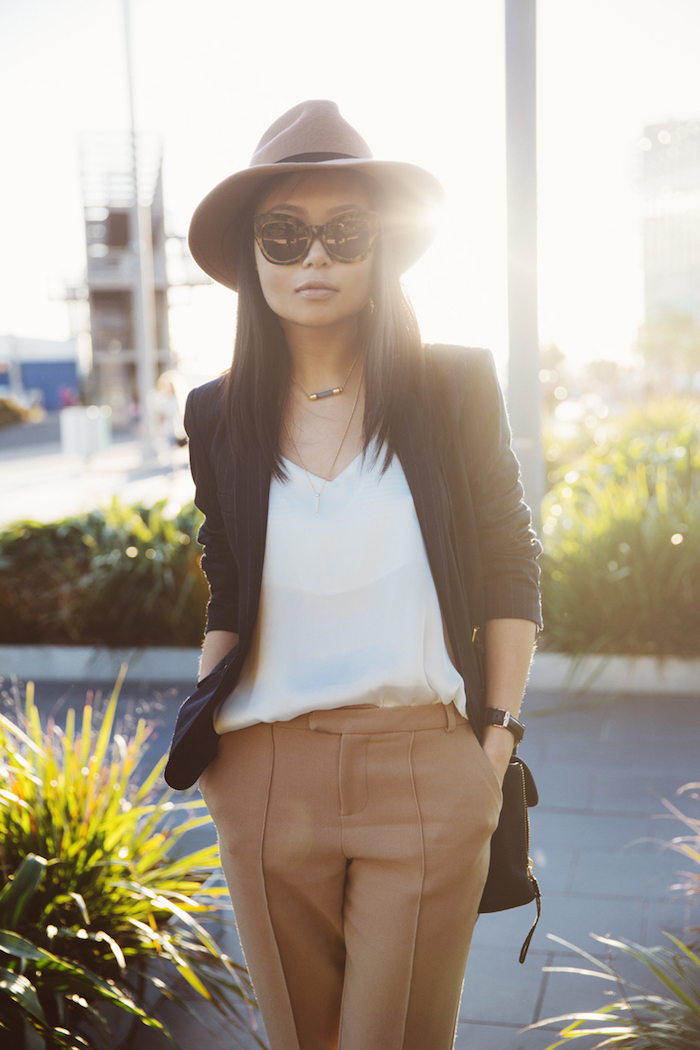 pantalon chino, style vestimentaire en chemise blanche et blazer noir, accessoires femme capeline et lunettes de soleil