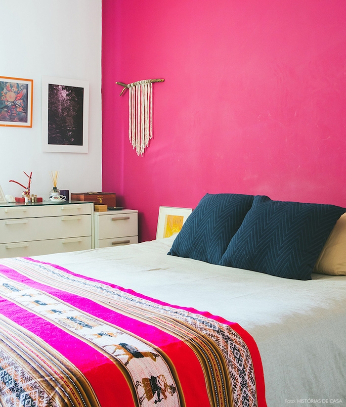 peinture chambre adulte avec mur d accent rose fuchsia, coussins noirs, couverture e lit motifs orientaux, commode blanche, deco murale macramé