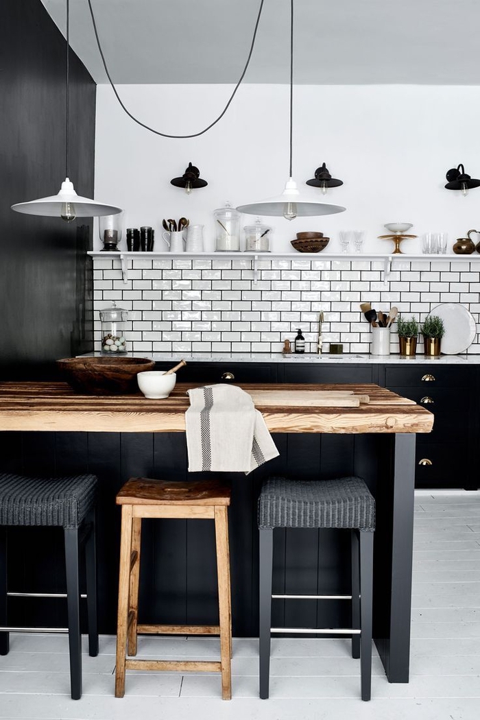 cuisine élégante en noir et blanc avec une crédence en briques métro associant une ambiance deco industrielle au chic scandinave