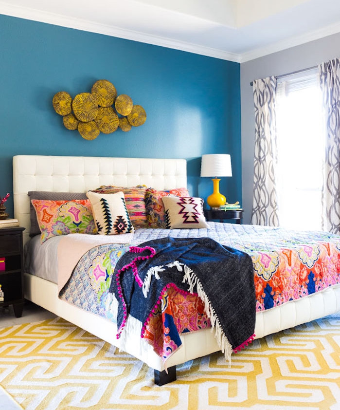 deco chambre parentale avec pan de mur bleu, linge de lit coloré aa motifs floraux, style boheme chic, tapis blanc et jaune