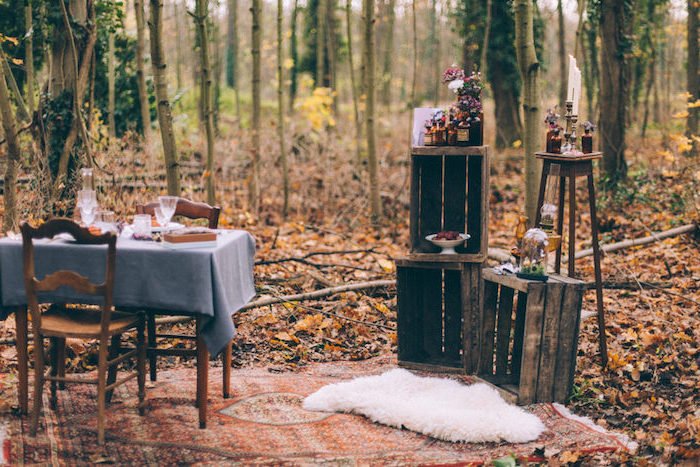 diy mariage en plein air, automne, cagettes en bois avec decoration florale, table et chaises en bois, nappe grise et couverture orientale