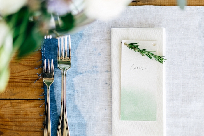 deco table mariage, couverts simple, marque place originale facile à créer, étiquette blanc et vert, brin de pin, sous assiette bleue t blanc