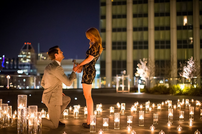 idée de demande en mariage romantique au toit d un bâtiment en pleine ville, plusieurs lanternes bougies pour une ambiance romantique