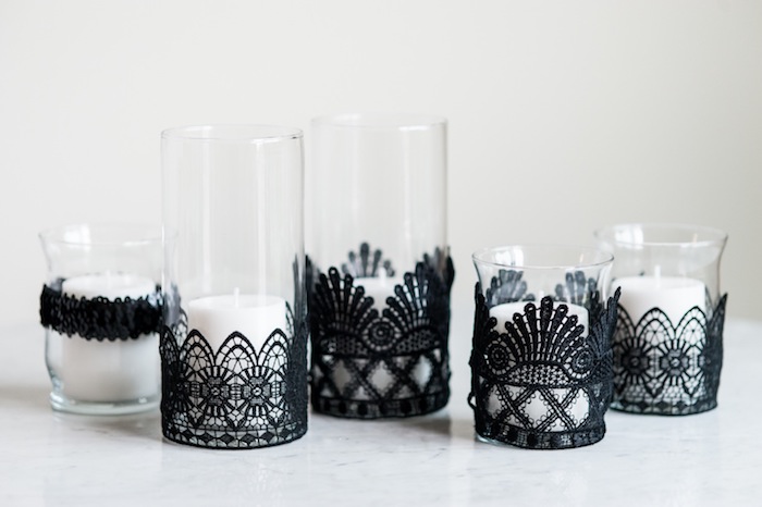 bougies blanches dans des verres, décorés de bandes de dentelle noire, décoration halloween e fabriquer