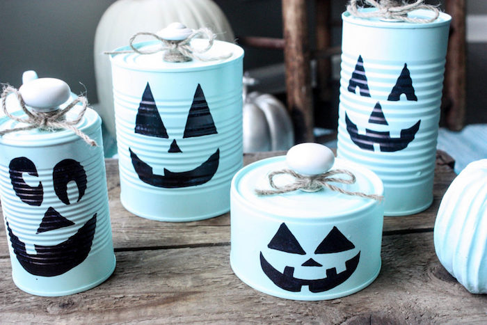 des boites de conserve repeinte en bleu avec dessin jack o lantenr à la peinture noire, activité manuelle halloween facile