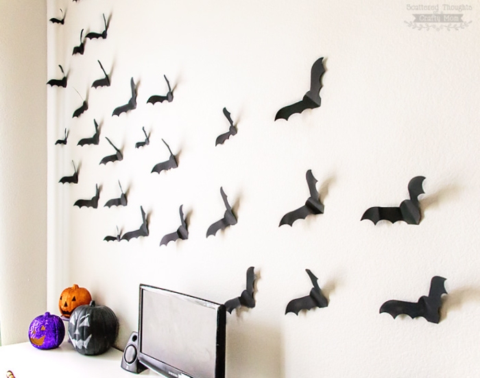 silhouettes de chauves souris en papier noir sur un mur, deco bureau avec des citrouille halloween repeinte, activite manuelle facile