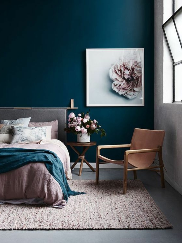 peinture chambre adulte avec mur en bleu pétrole et grand tableau avec une fleur au cadre blanc avec tapis en rose et petits détails noirs