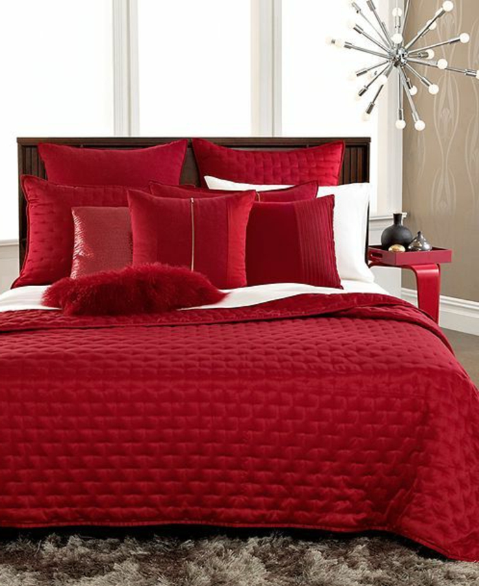 idée déco chambre adulte en rouge rubin avec des grands coussins moelleux et couverture effet matelassée