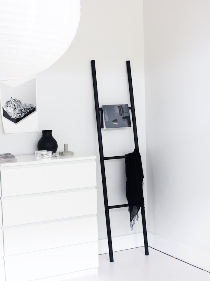 deco salon scandinave, echelle decorative noire, rangement magazines et textiles, meuble blanc et fond mur blanc