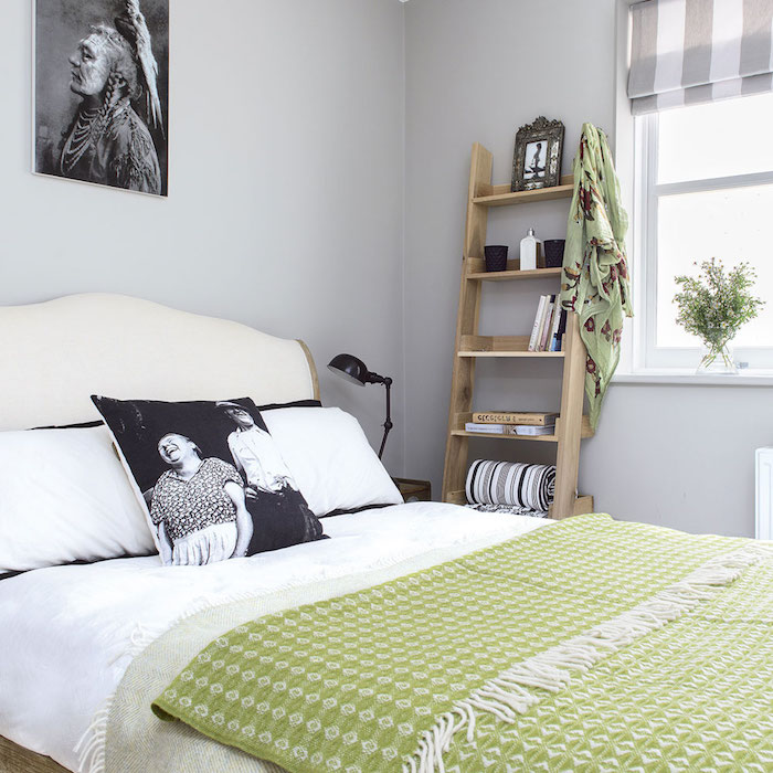 echelle etagere en bois avec des rangements avec accessoires deco et livres, linge de lit blanc, couverture vert pistache, deco murale graphique