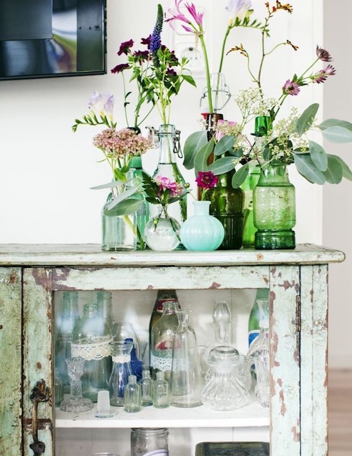 exemple de vaisselier campagne chic, repeinte de couleur vert menthe, aspect vieilli, rouillé, deco de vases de fleurs