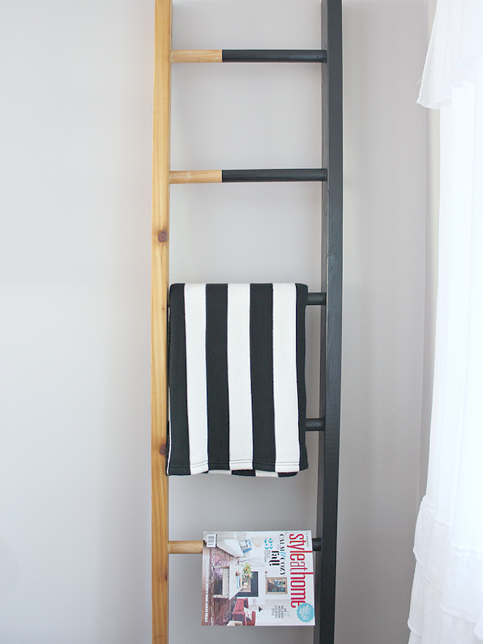 echelle deco bois, à moitié repeint en noir, range magazines et textiles, point focal dans un salon moderne