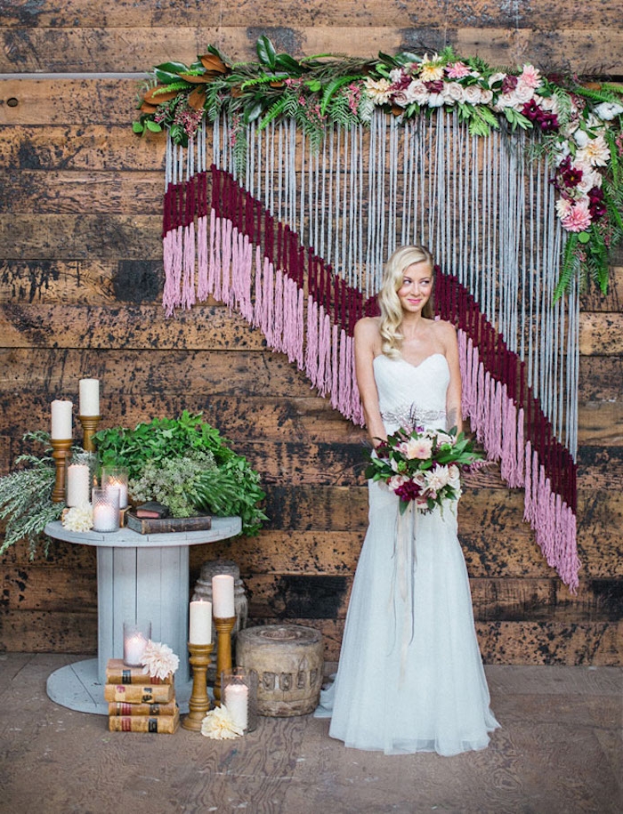 deco salle mariage, macramé et gris, rouge et rose, sur un fond en bois, touret bois deco gris avec bougies, bouquins et fleurs