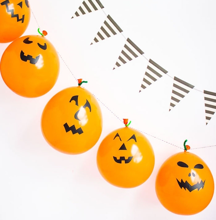 fabriquer une guirlande à partir de ballons couleur orange jack o lantern, rangés sur une ficelle, guirlande à fanions, deco halloween a faire soi meme