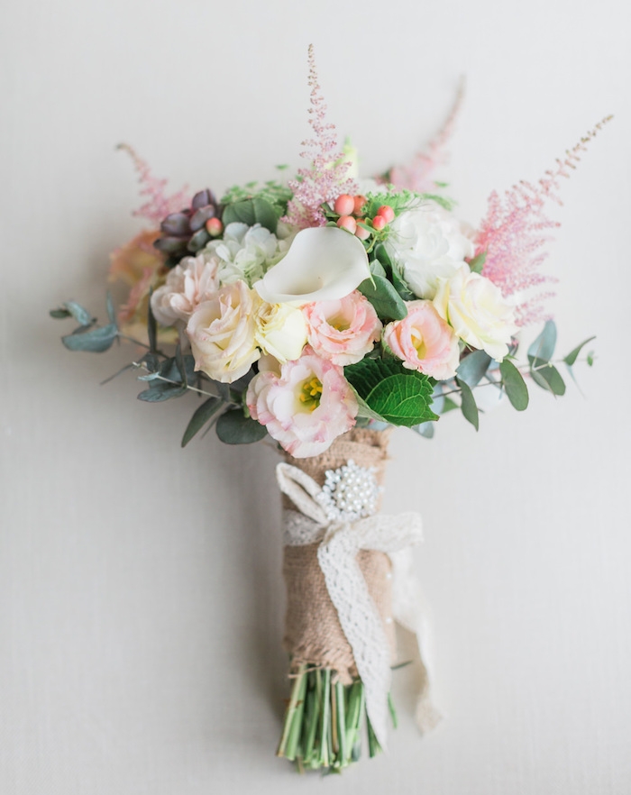 idee deco mariage, bouquet de fleur mariée avec des fleurs printanières et tiges enveloppées de bande de jute et ruban dentelle blanche, perles