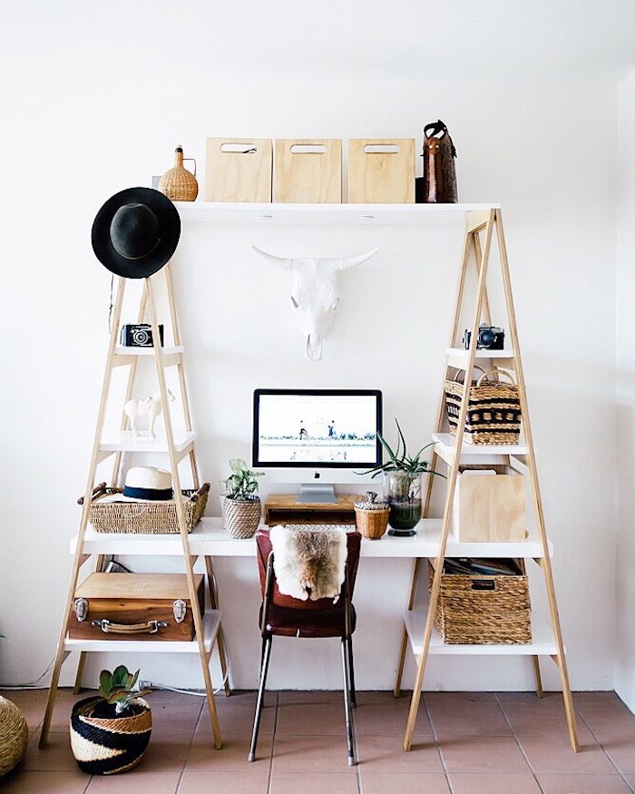 bureau style scandinave fabriqué à aprtir de deux échelles et un plateau blanc qui les réunit, chaise en metal et cuir, accents deco paniers, malles vintage, chapeau melon