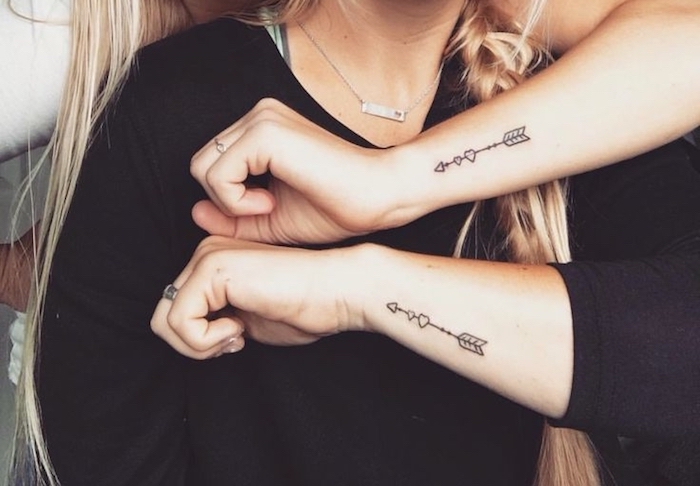 femme tatoué, dessin sur les mains à design flèches et coeurs, tatouage pour des amies