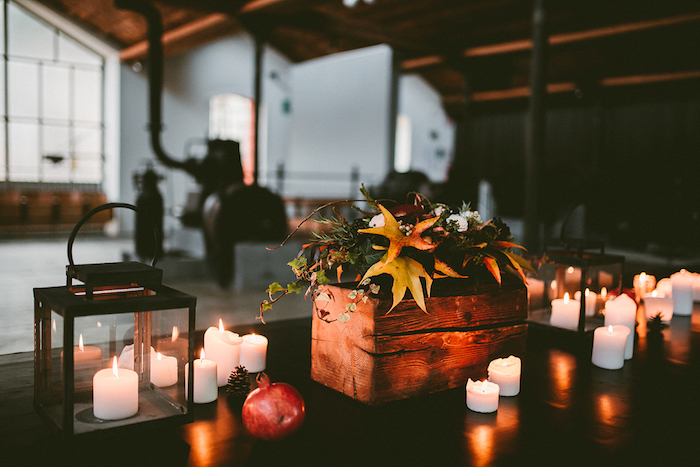idee deco mariage automne avec un bac en bois avec des fleurs en guise de centre de table, bougies, lanterne noire, pomme de pin