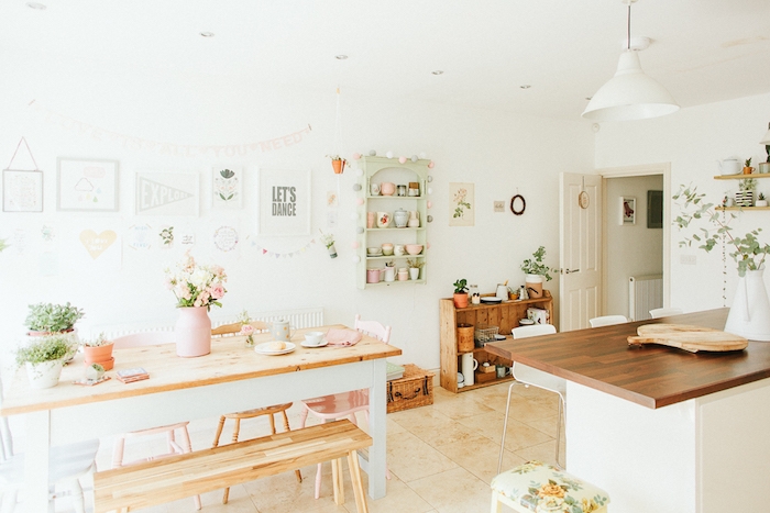 idée relooking cuisine dans des tonalités pastel, plan de travail, table, banc et chaises en bois, étagère vert pastel, vaisselle rose, vert et bleu pastel, deco murale gris et blanc