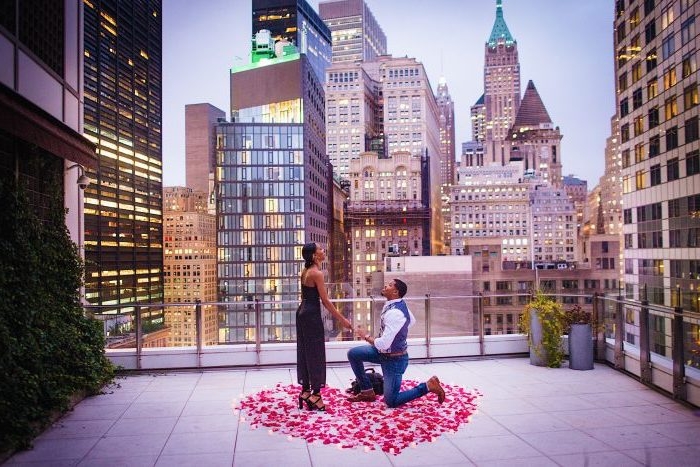 idée surprise mariage au toit d un batiment, milieu urbain, une coeur en pétales de roses et bougies autour