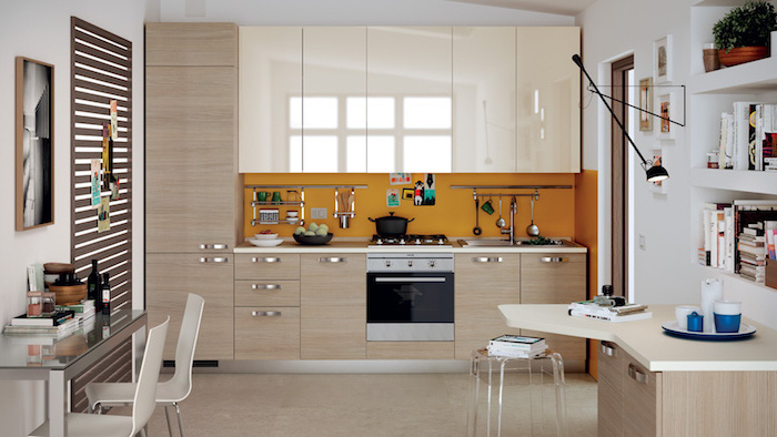 agencement cuisine, meubles de cuisine beige et blanc sans poignées avec crédence orange, petite table d'angle en bois clair