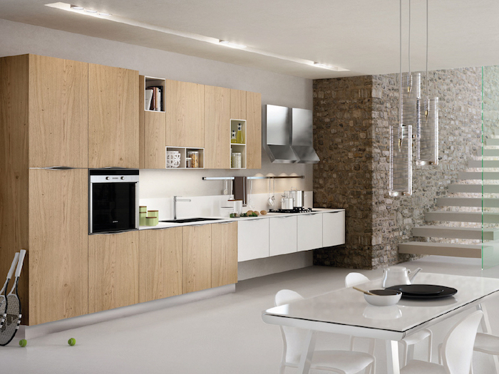 cuisine amenagee, meubles de cuisine en bois et blanc, mur en pierre et escalier en bois blanc, plafond blanc avec éclairage led